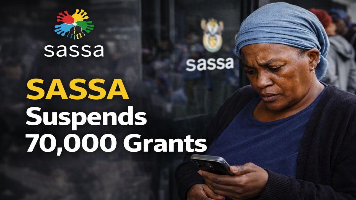 Woman checking her phone outside a SASSA office after grant suspension during beneficiary review process in South Africa